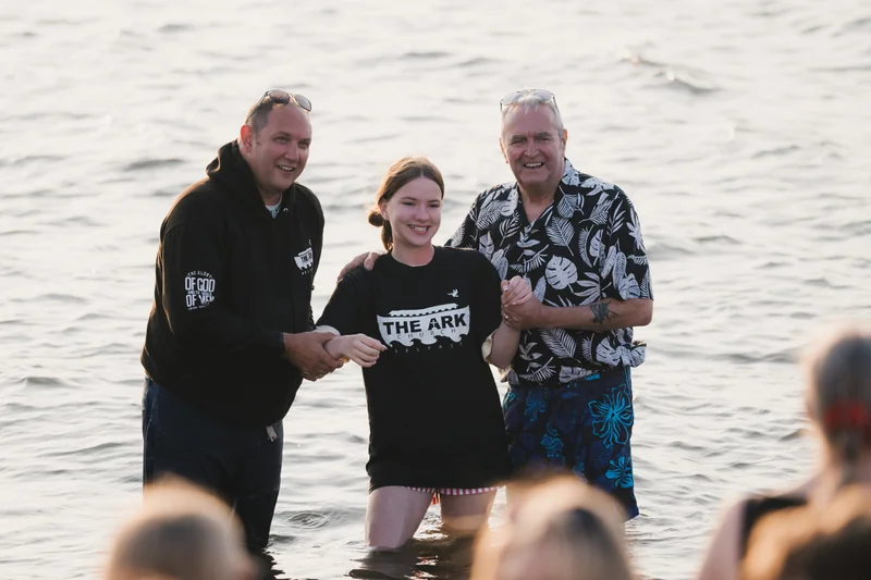 a man and woman are standing in the water with a woman in front of them