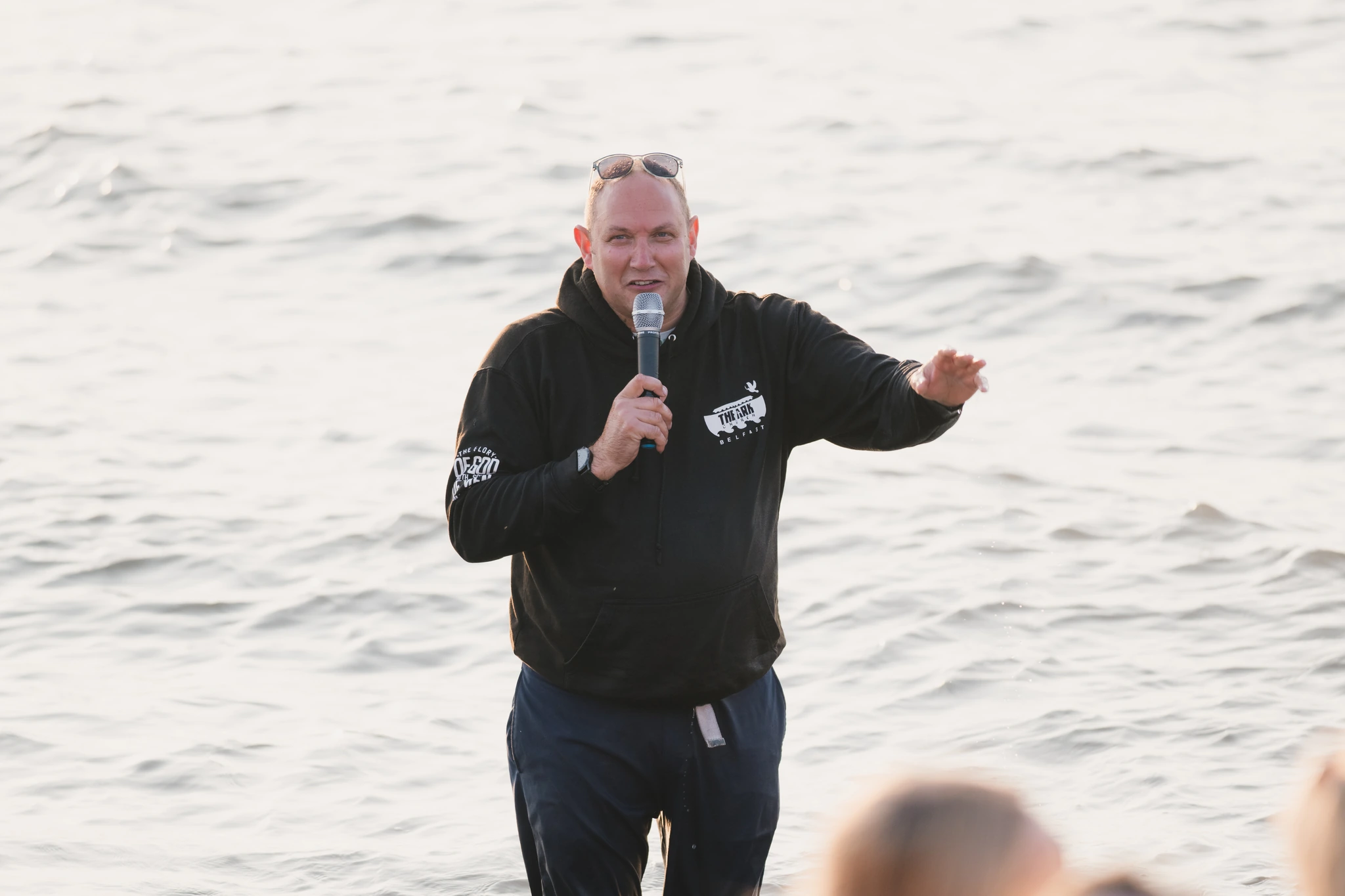 a man with a microphone standing in front of a crowd