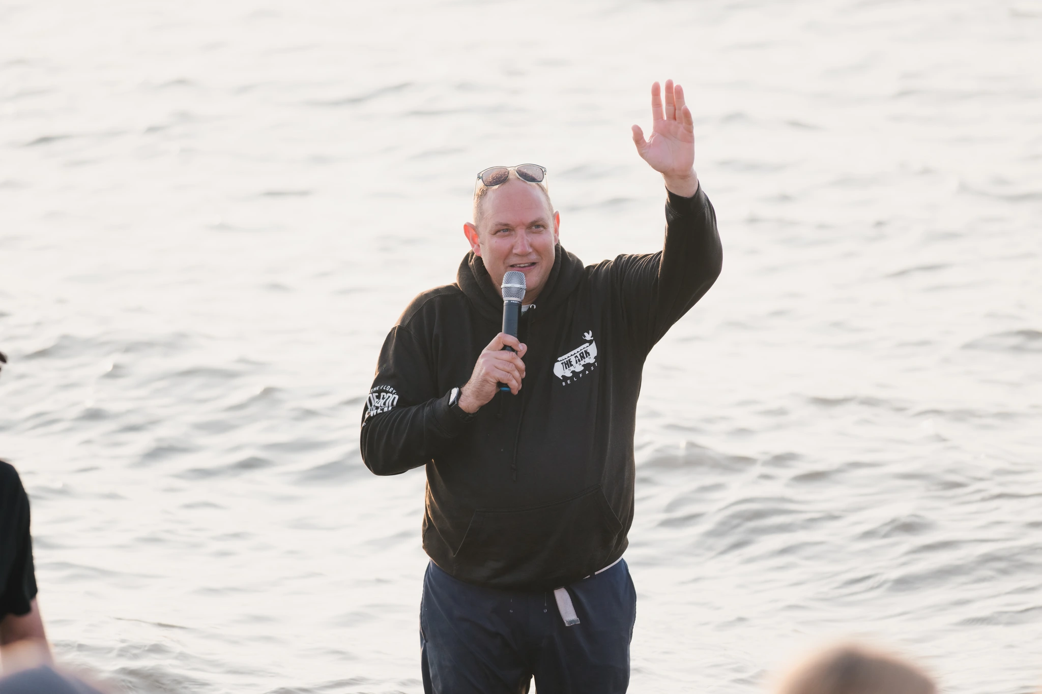 a man waving his hands in the air as he speaks to a crowd