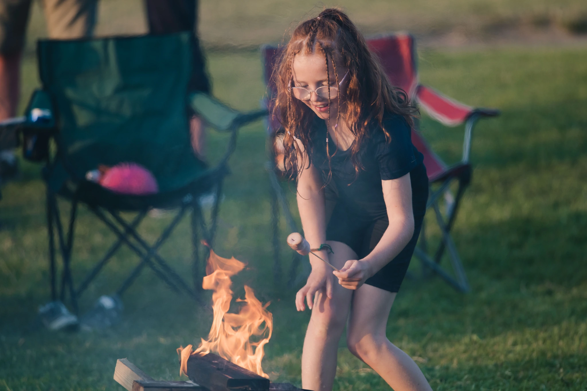 a little girl playing with a campfire