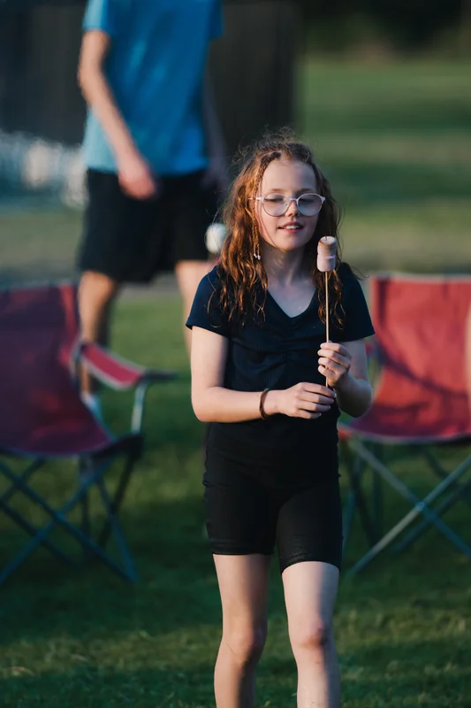 a girl holds a baton in a grassy field