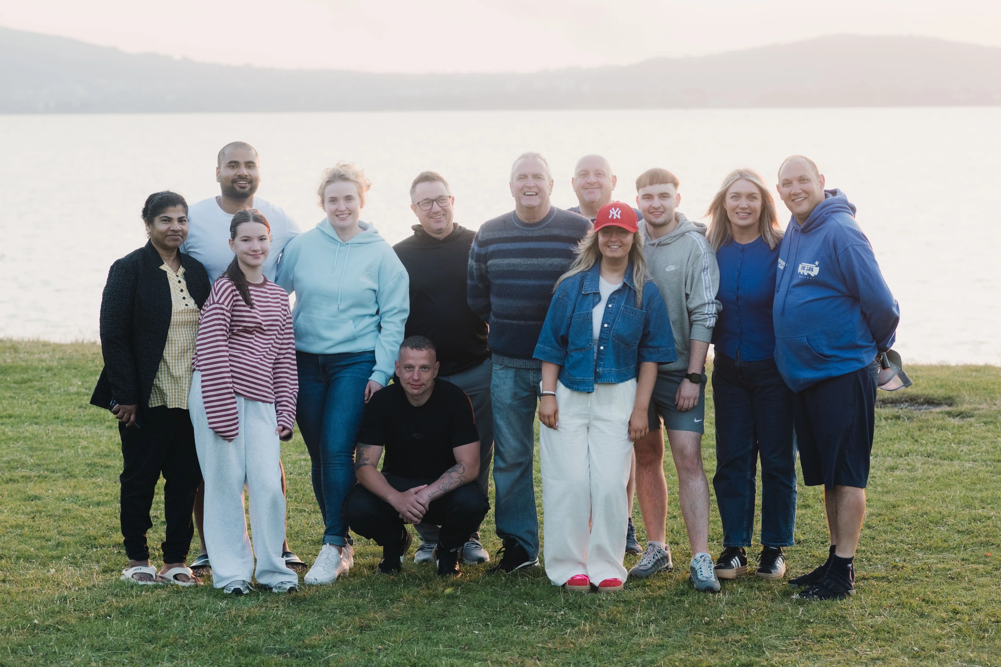 a group of people standing in front of a lake