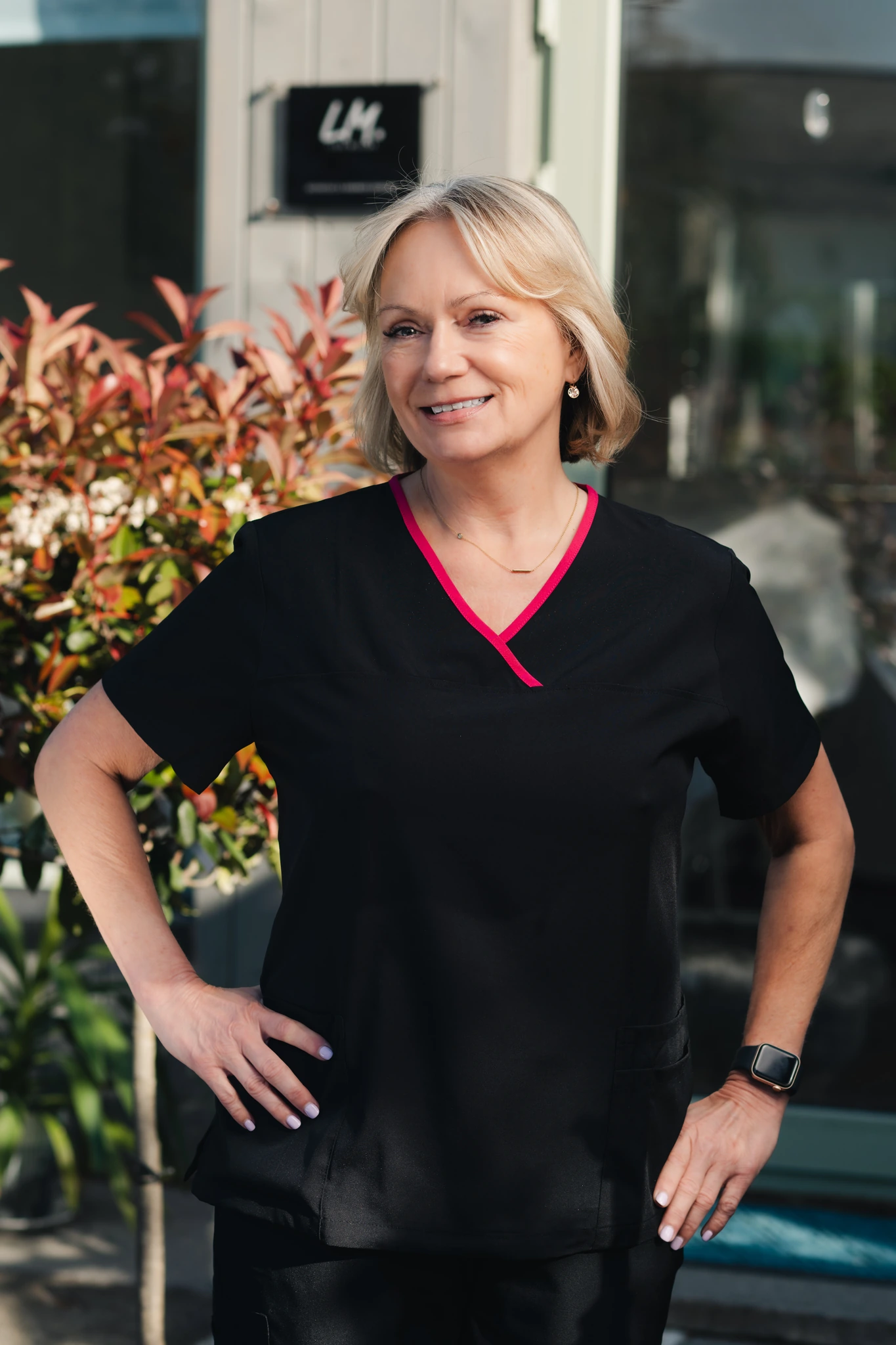 a woman in black scrubs standing in front of a building