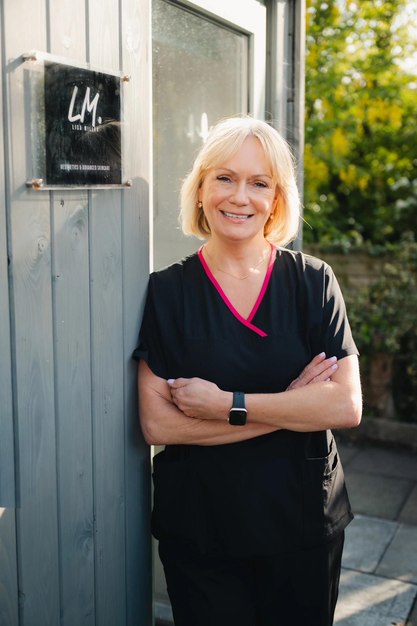a woman in a black apron standing in front of a wooden door