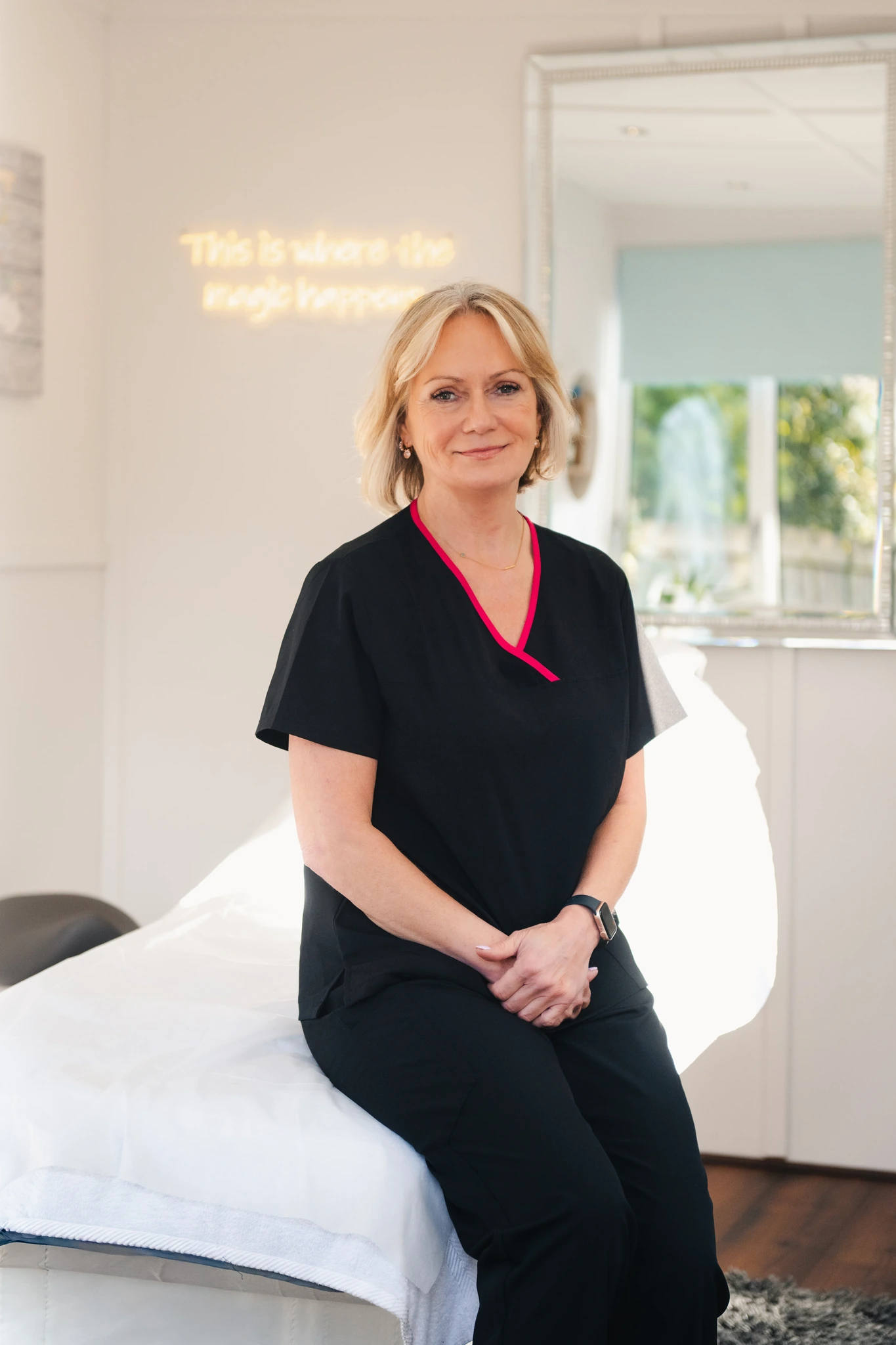 a woman sitting on a bed in a treatment room