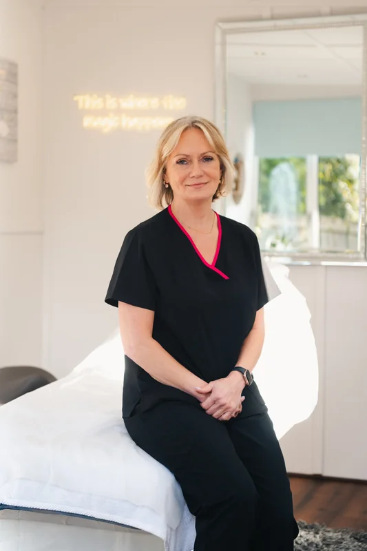 a woman sitting on a bed in a treatment room