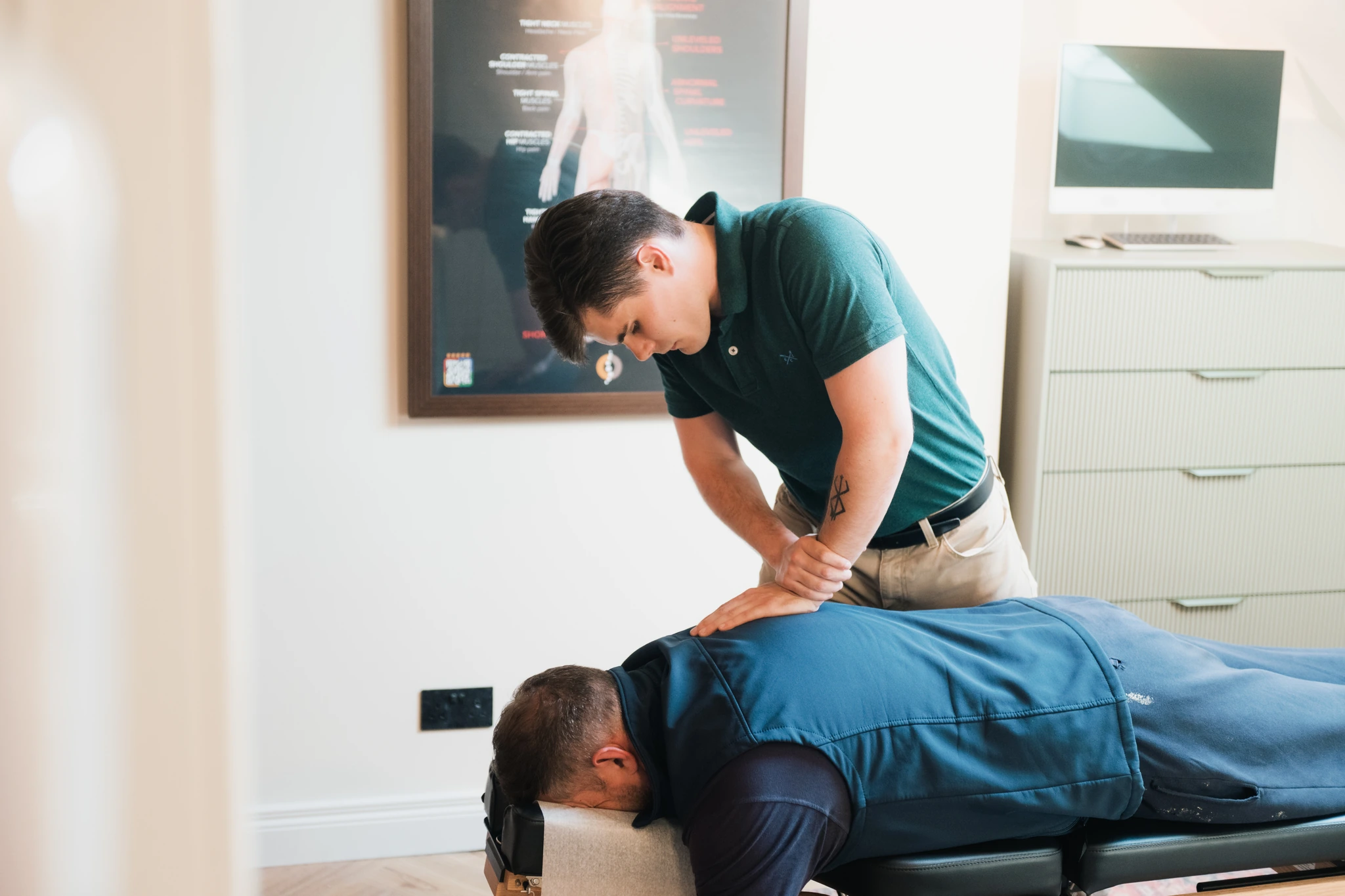 a man is being massaged by a massage therapist in an office