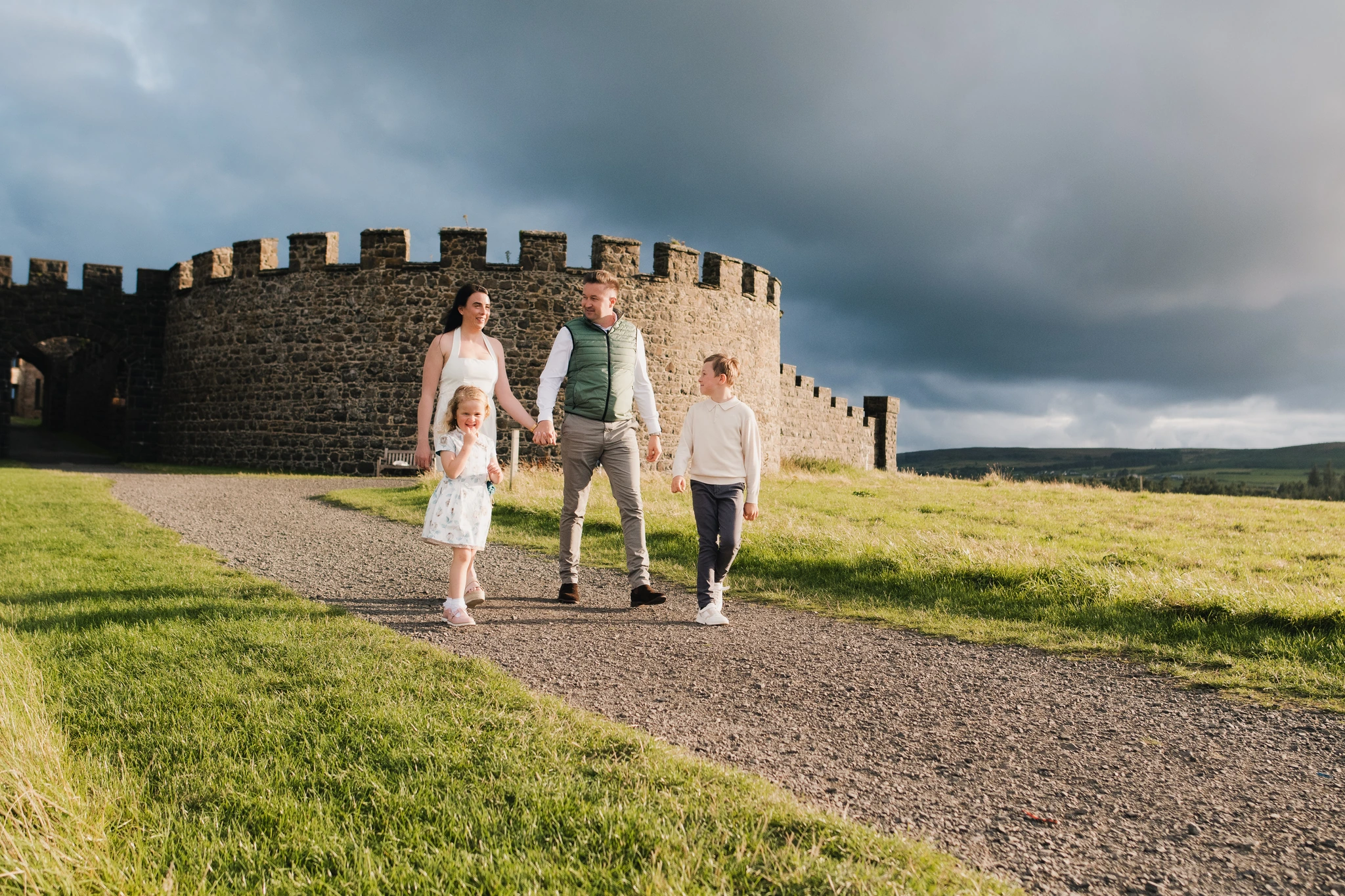a family walking down a path with a castle in the background