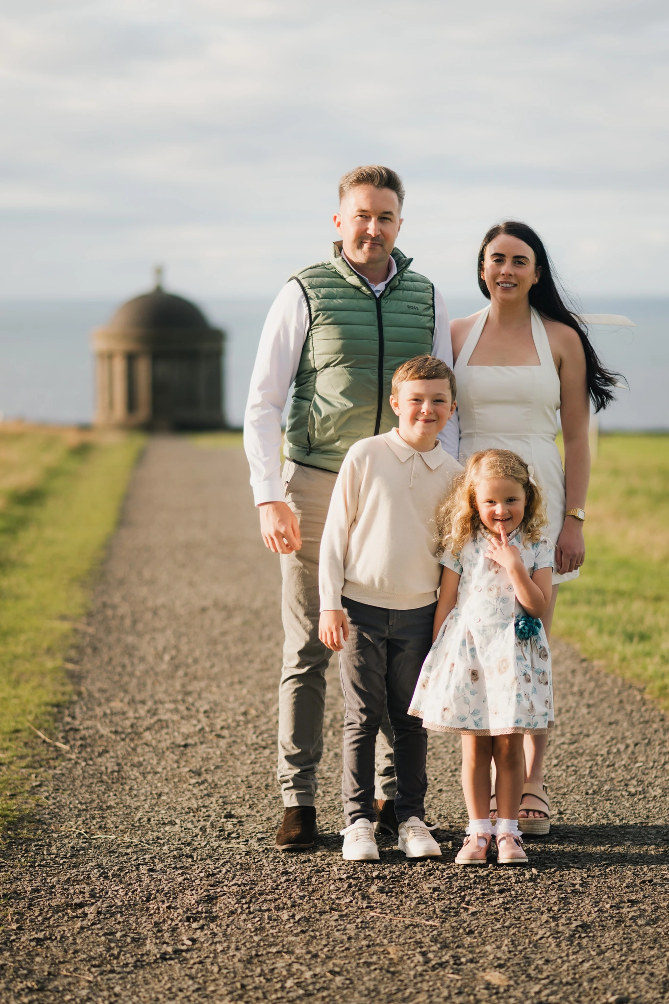 a family poses with their children on a path in front of a castle