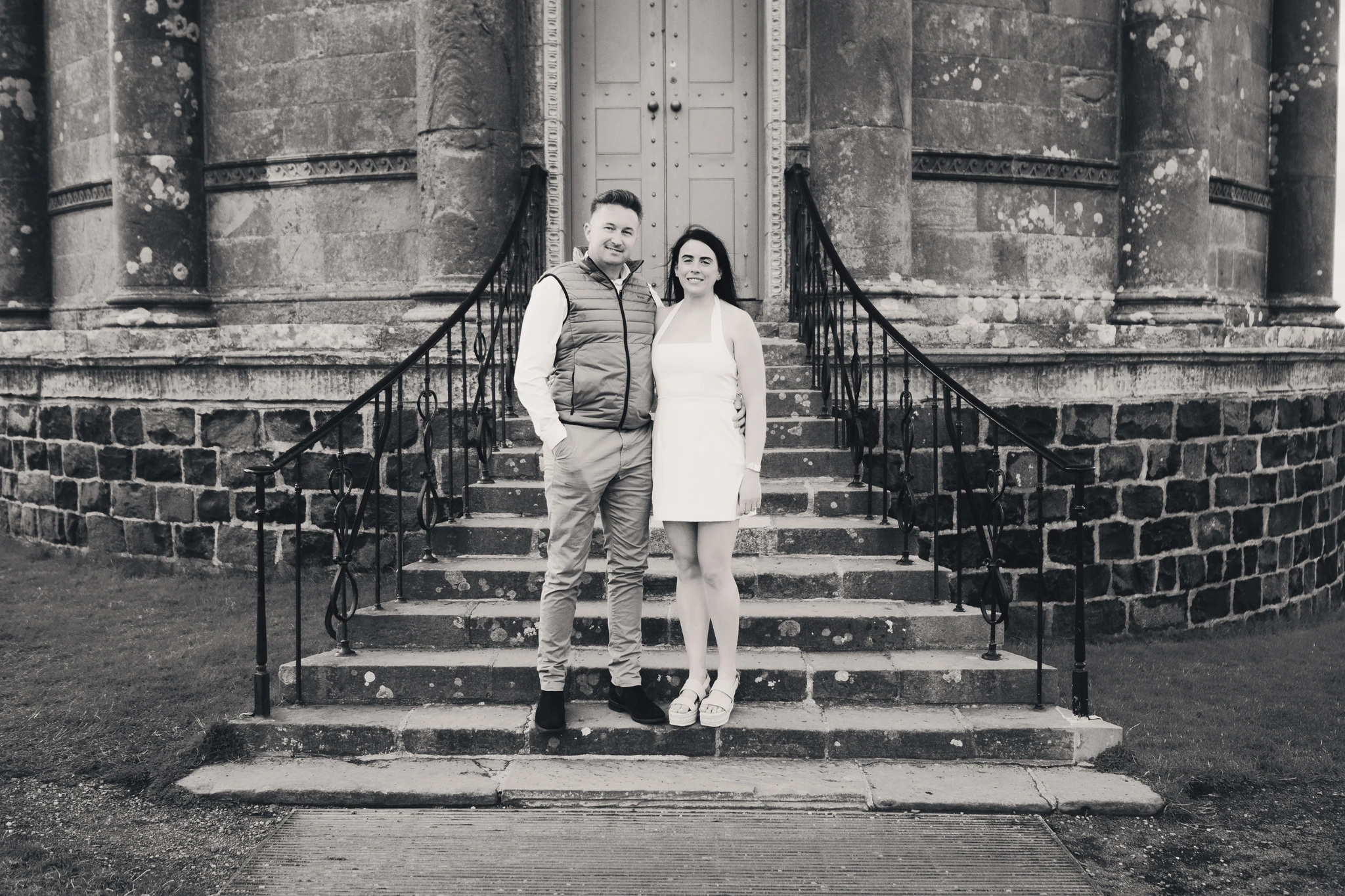 a man and woman standing on steps in front of a building