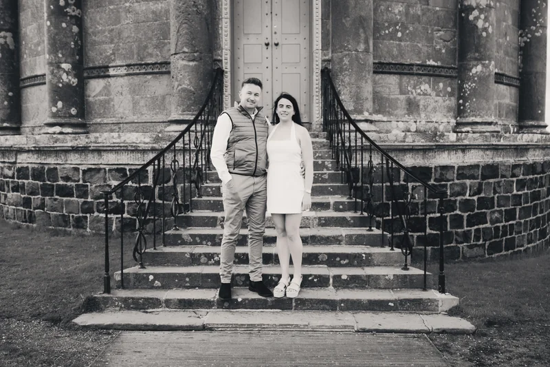 a man and woman standing on steps in front of a building