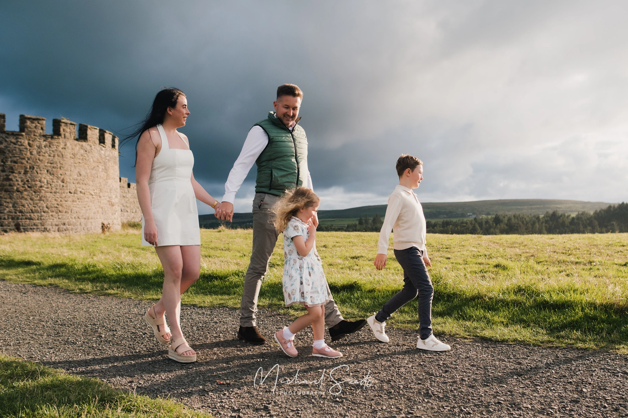 a family is walking down a path towards a castle