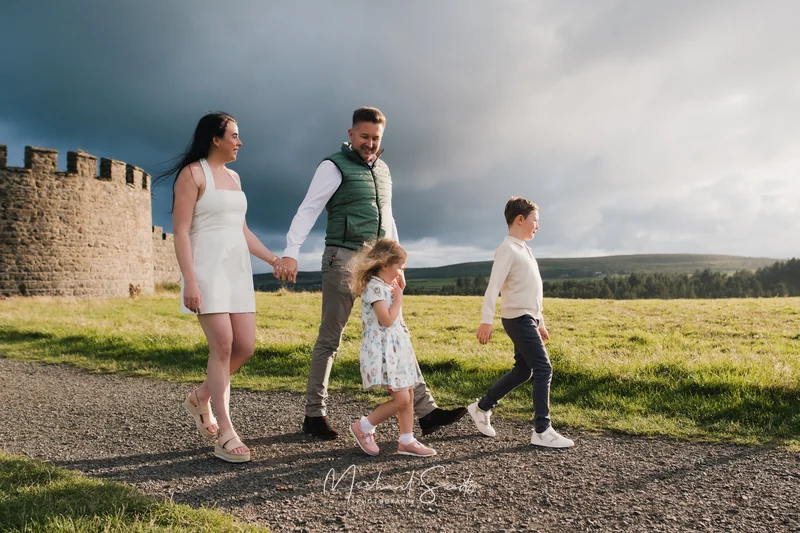 a family is walking down a path towards a castle