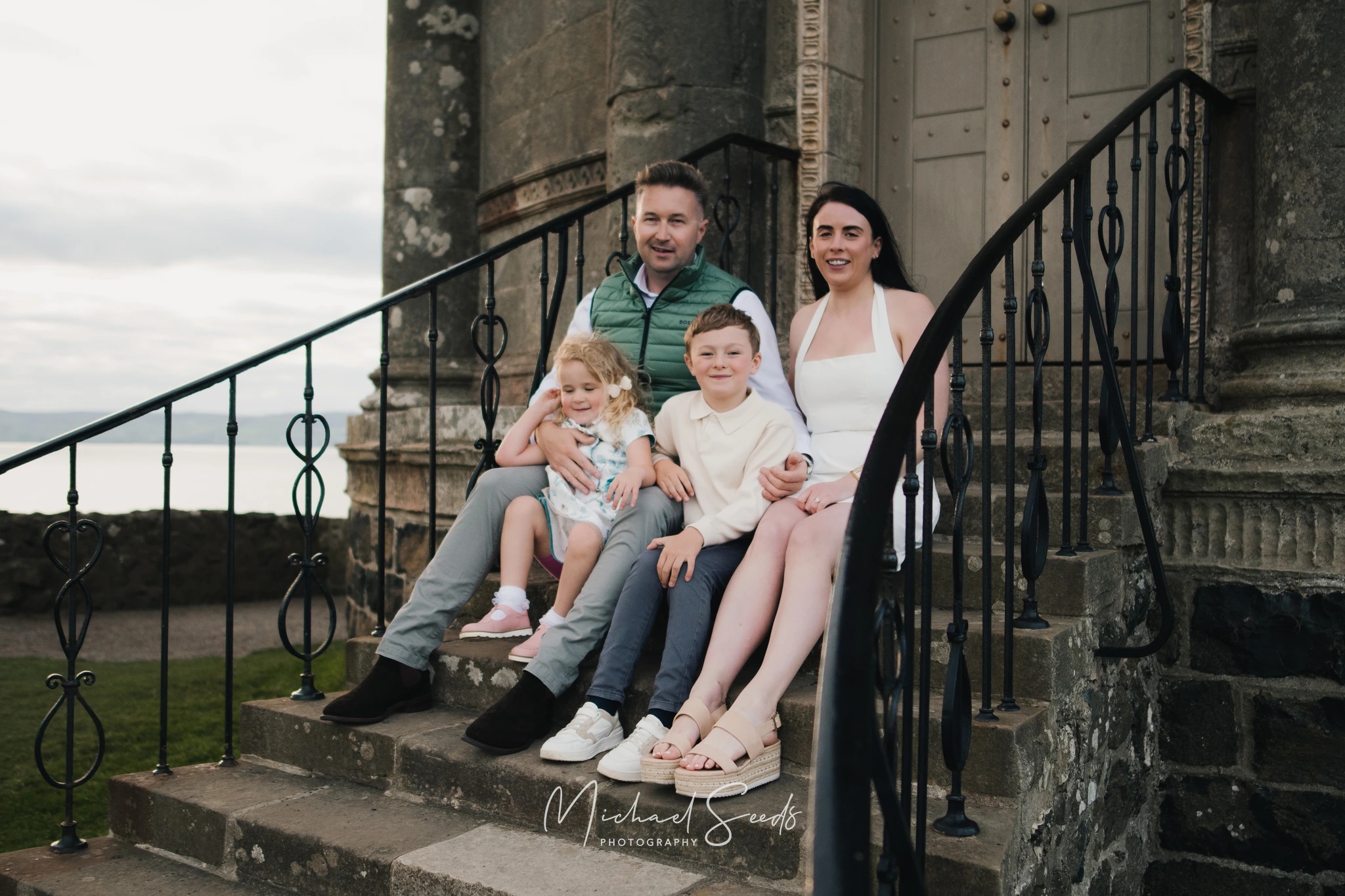 a family sits on the steps of a castle