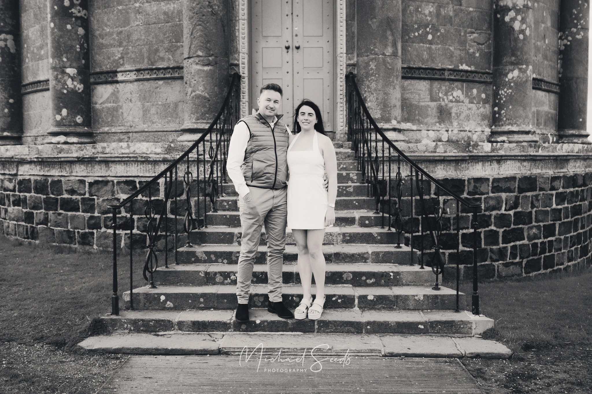 a man and woman standing on steps in front of a building