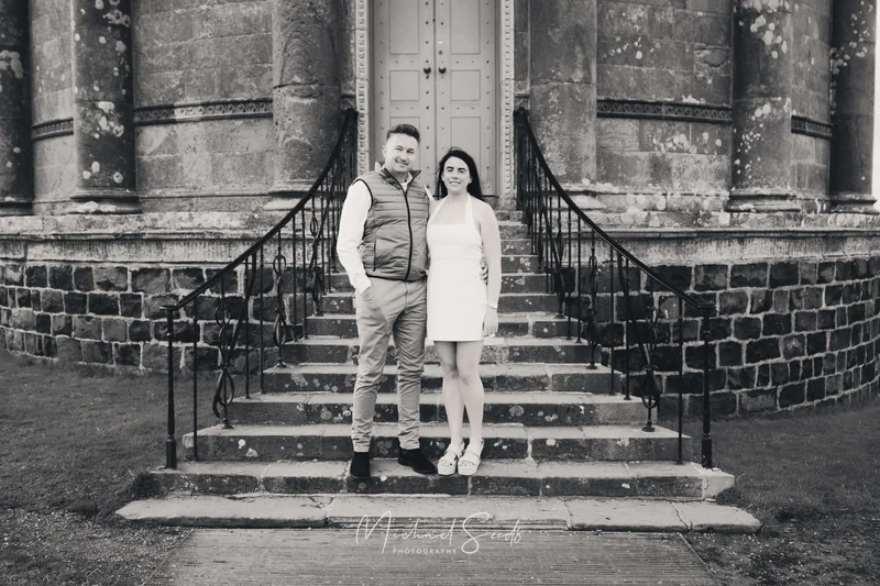 a man and woman standing on steps in front of a building