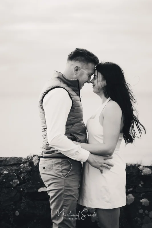 a bride and groom kissing on the beach during their engagement session