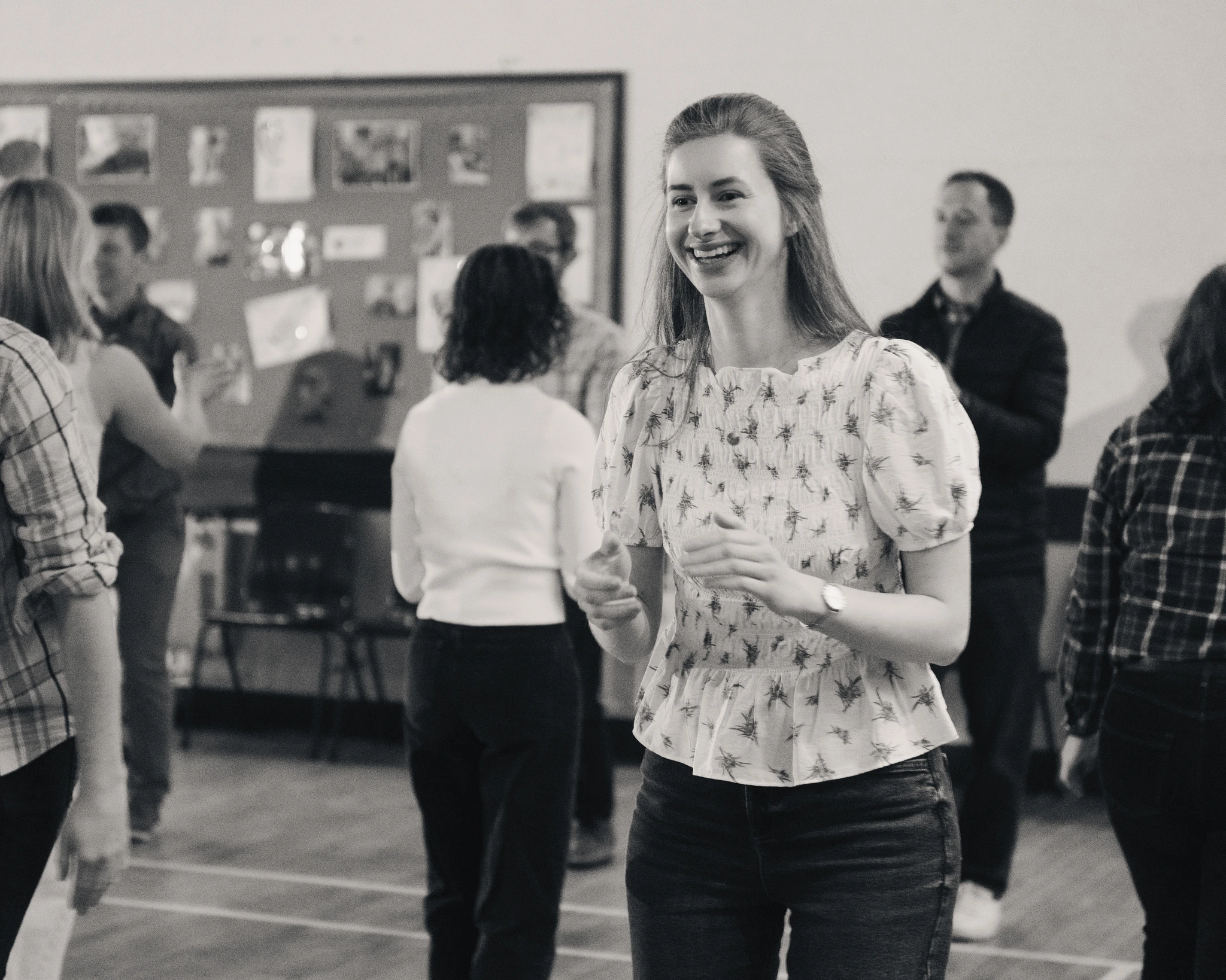 black and white photograph of a group of people dancing in a room