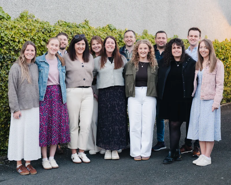 a group of people standing in front of a wall