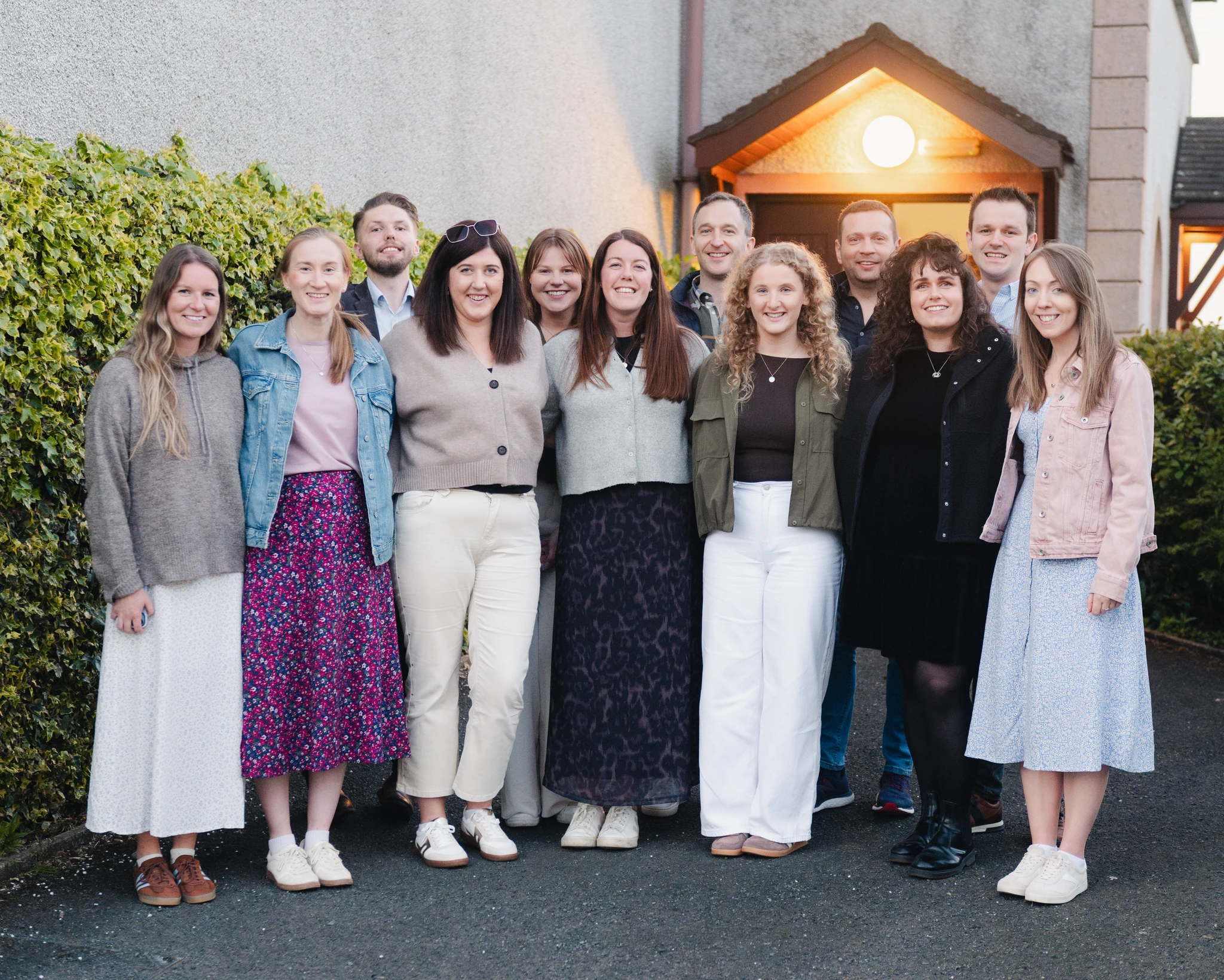 a group of people standing in front of a house