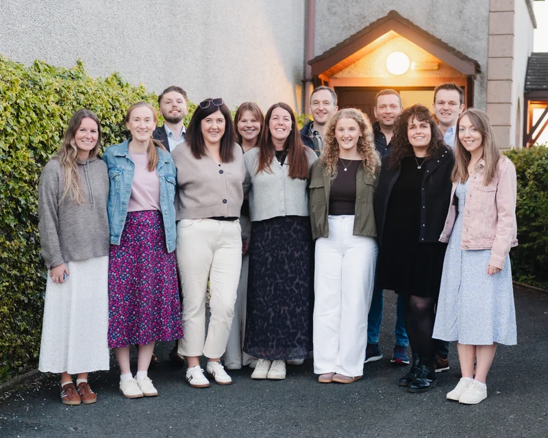 a group of people standing in front of a house