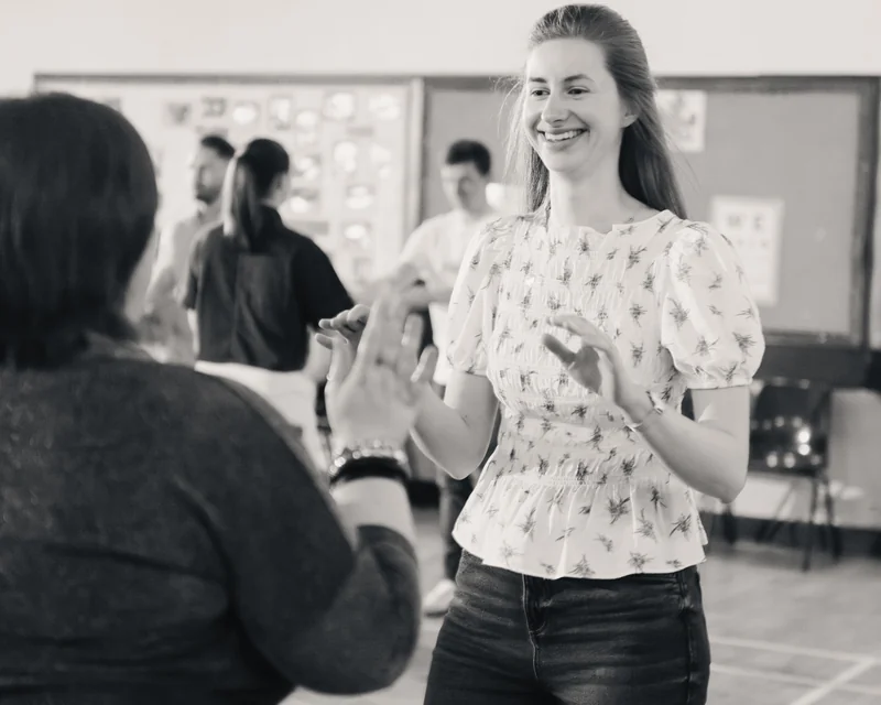 black and white photograph of a woman dancing in a classroom