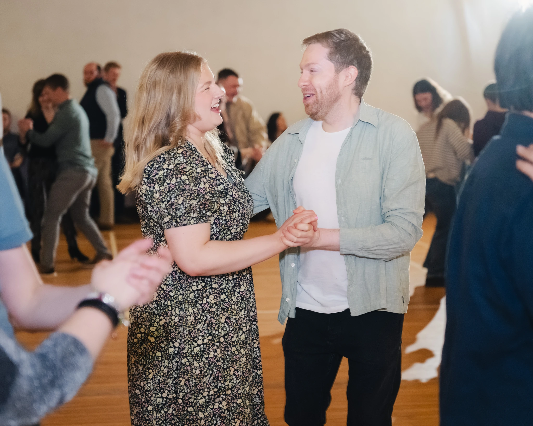 a man and woman dancing in a room full of people