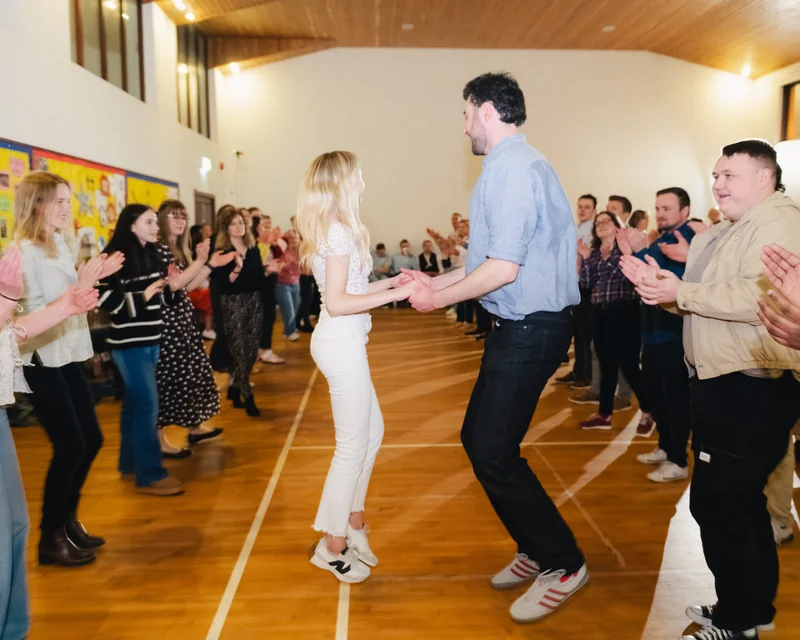 a man and woman dancing on a dance floor in front of a crowd of people