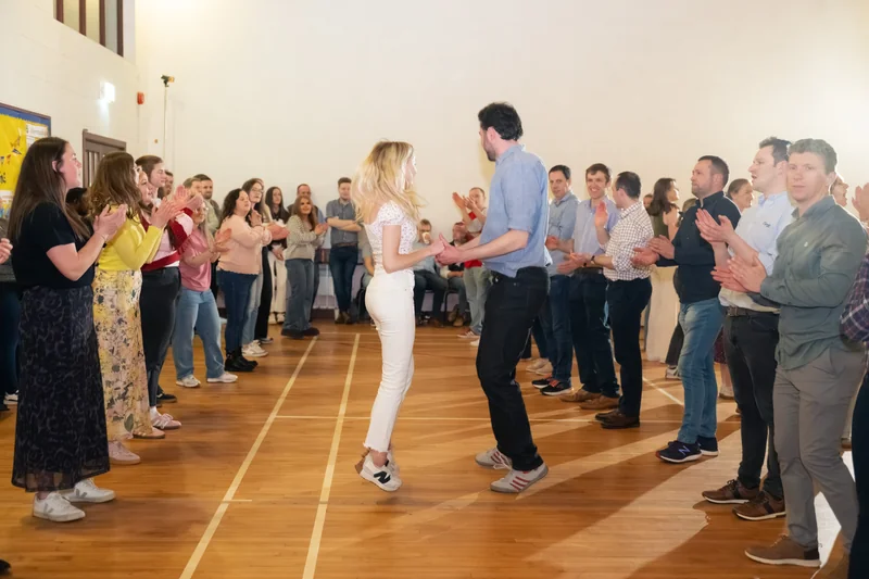 a man and woman dancing in a room full of people