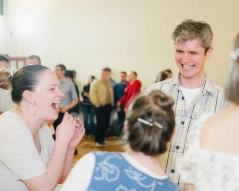 a group of people laughing and dancing at a dance party
