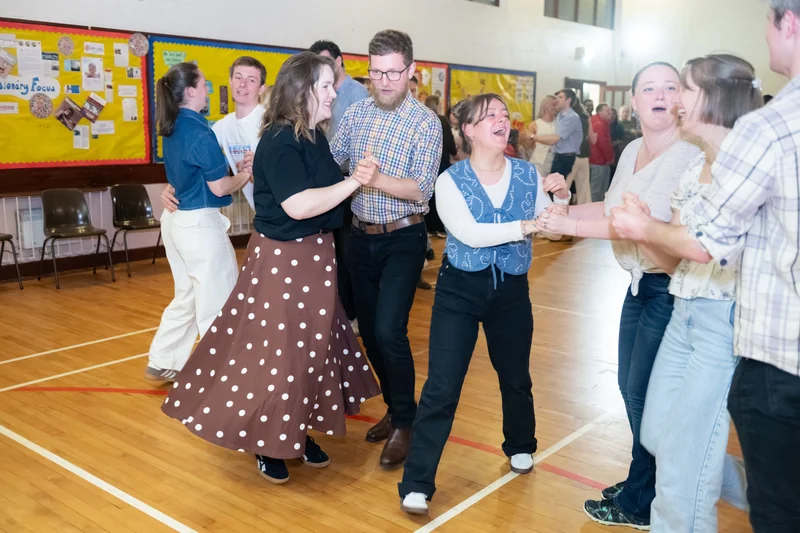 a group of people dancing in a gymnasium