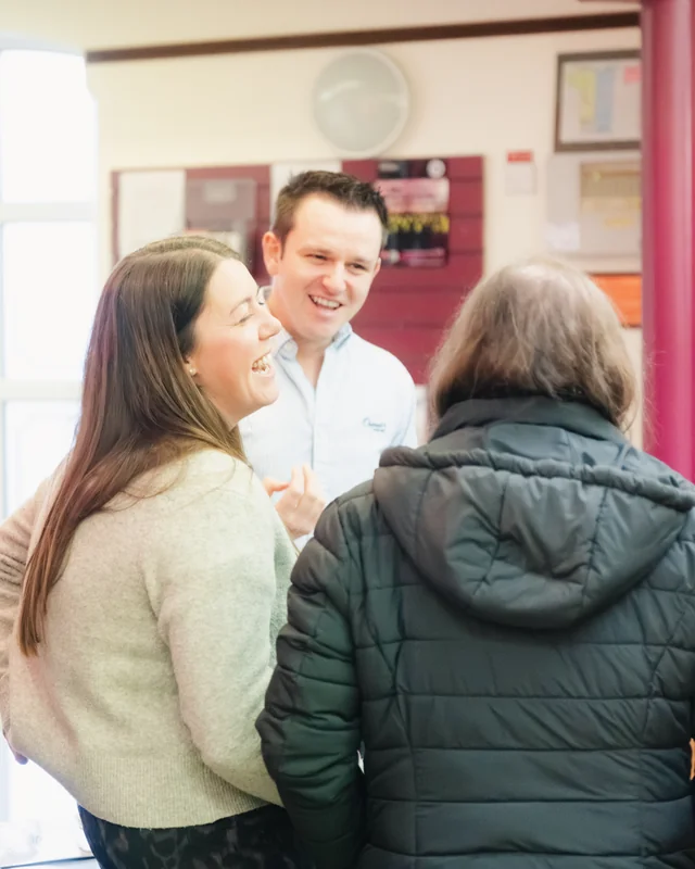 a group of people standing around a table in a room