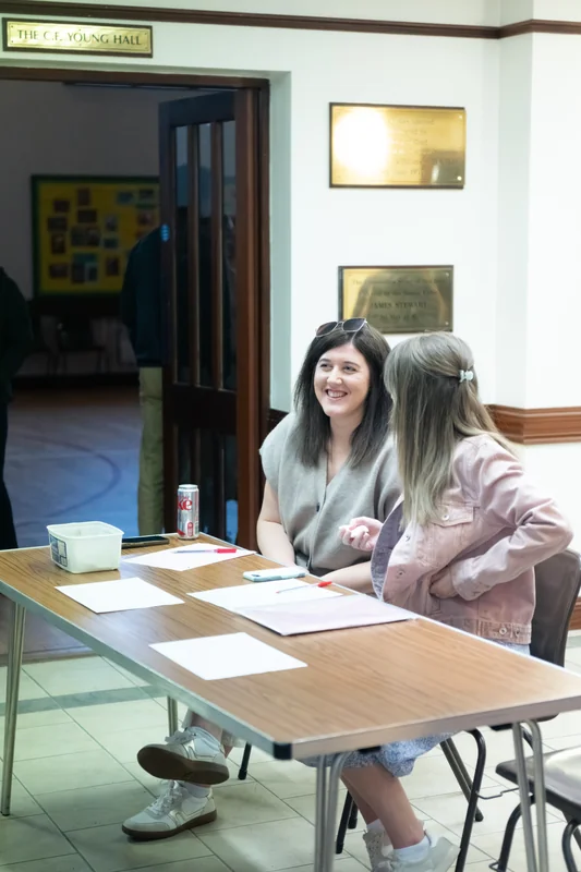 a group of girls at a table in a room with a long table and chairs