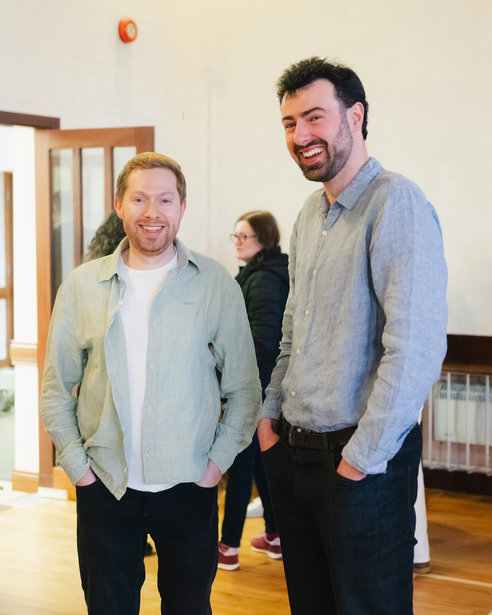two men standing next to each other in a room