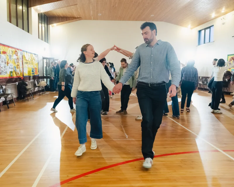 a man and woman dancing in a gymnasium