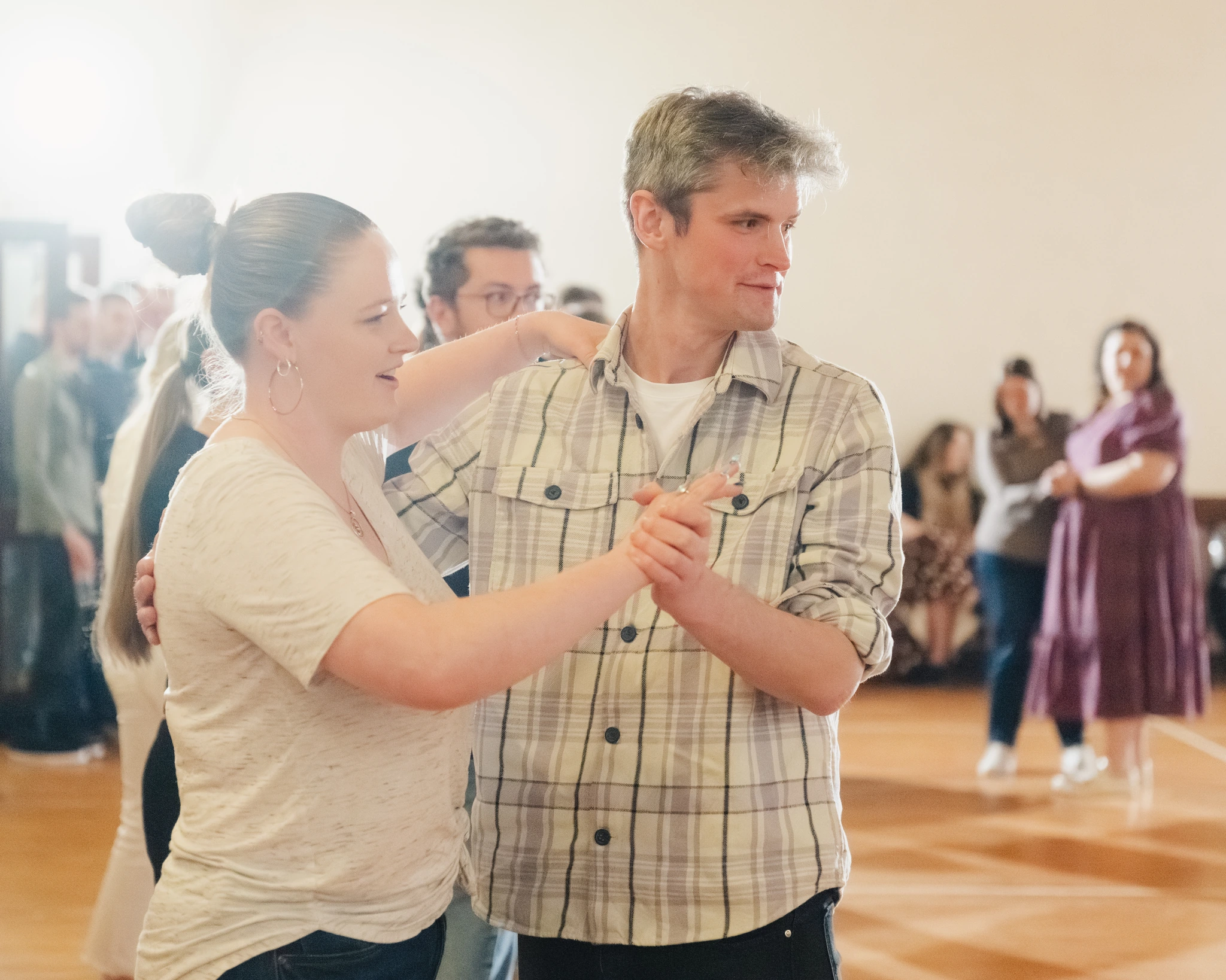a man and woman dancing in a room full of people