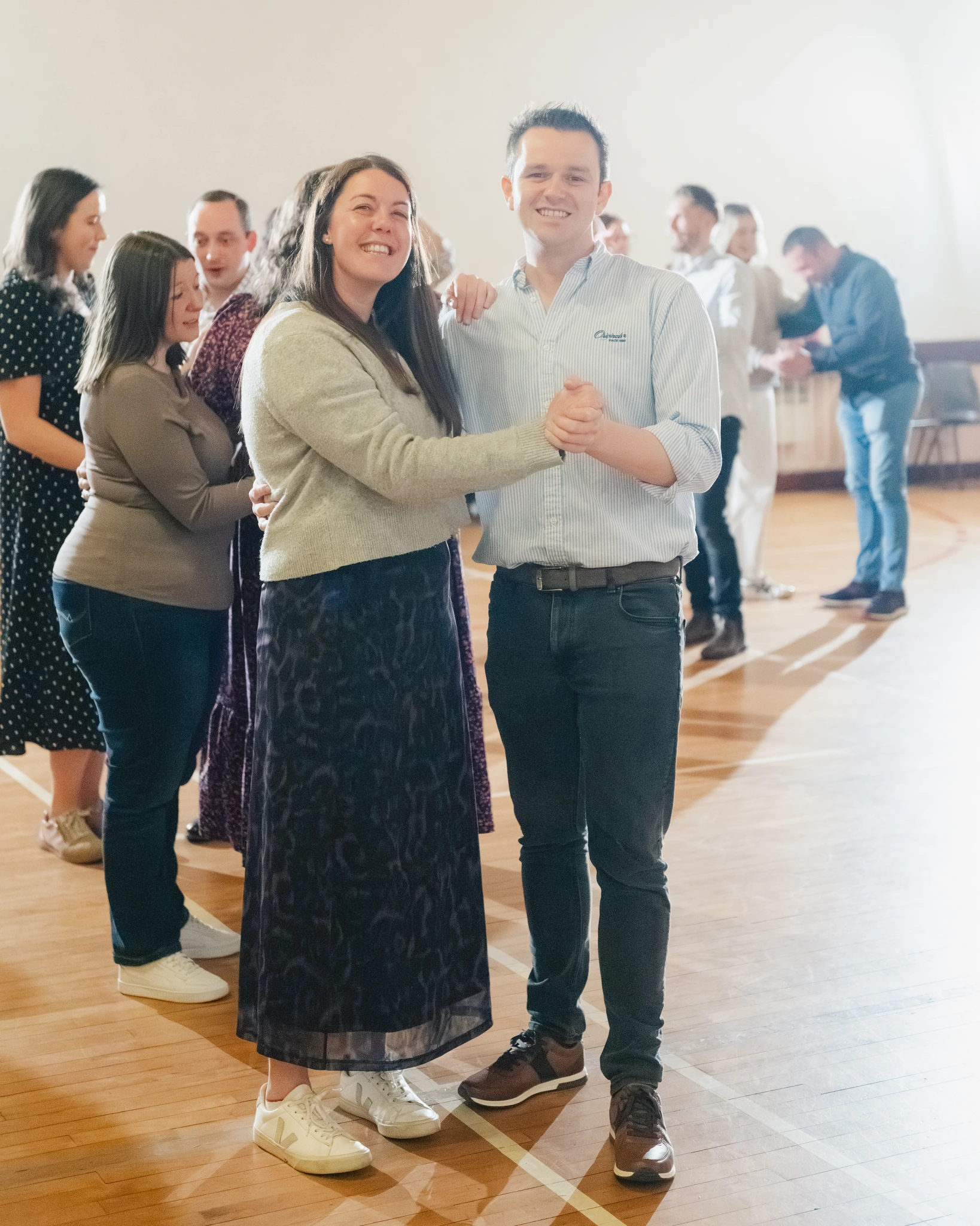 a man and woman dancing in a room full of people