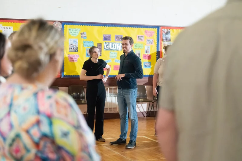 a group of people standing in front of a poster in a classroom