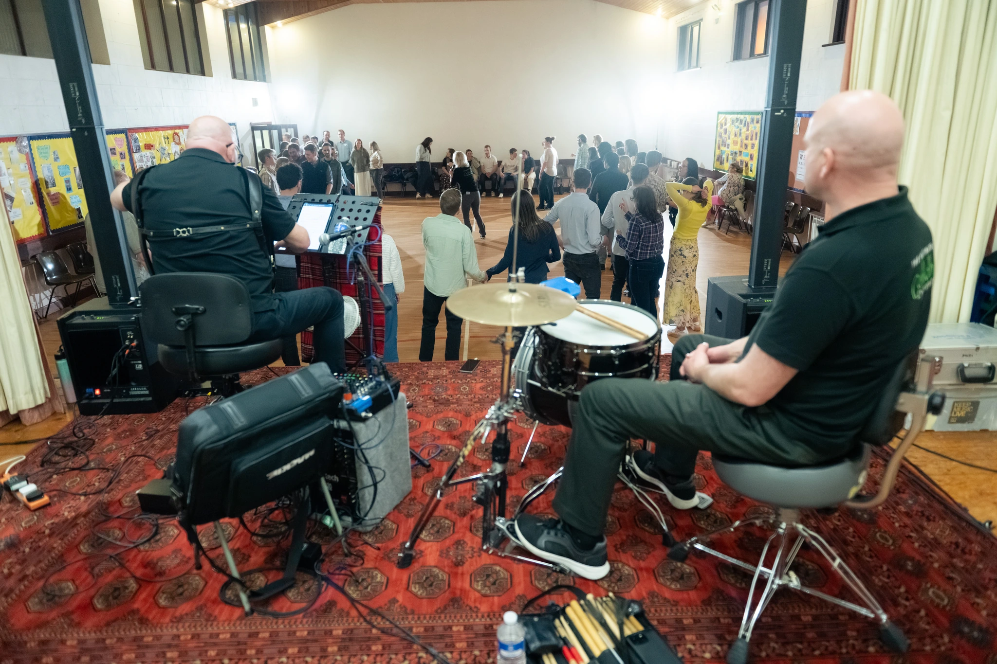 a group of people playing drums in a large room