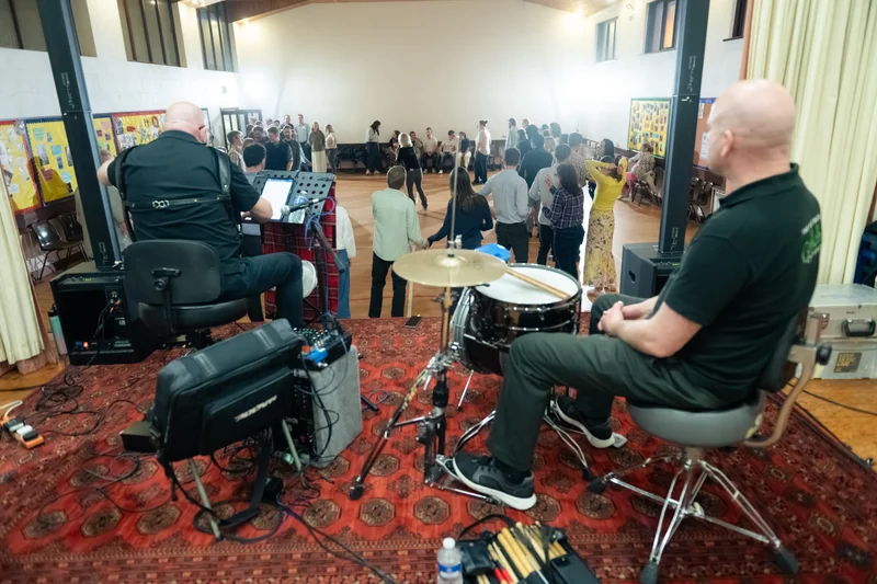 a group of people playing drums in a large room