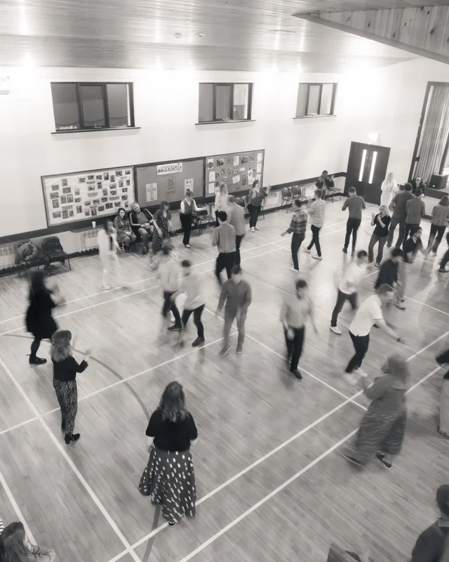 a group of people dancing in a gymnasium