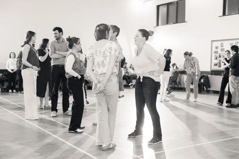 black and white image of a group of people dancing in a room