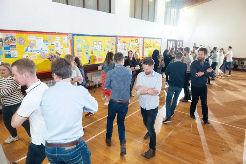 a group of people standing in a room full of people