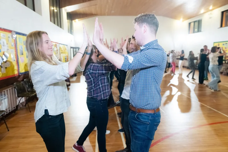 a group of people doing a dance routine in a gymnasium