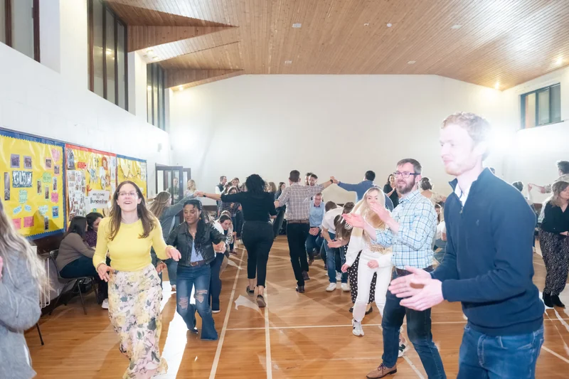 a group of people dancing in a gymnasium