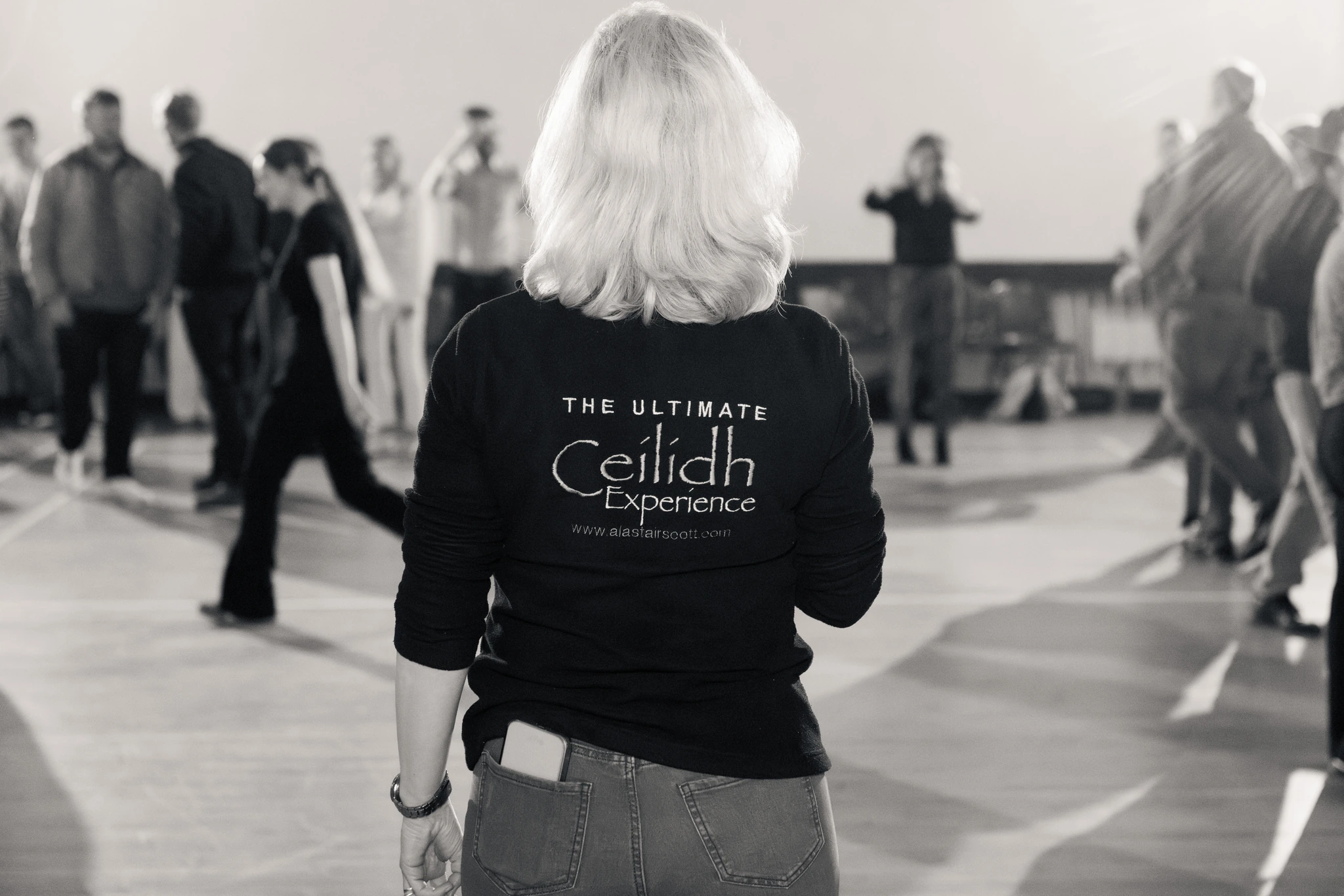 a woman in black and white standing in front of a group of people