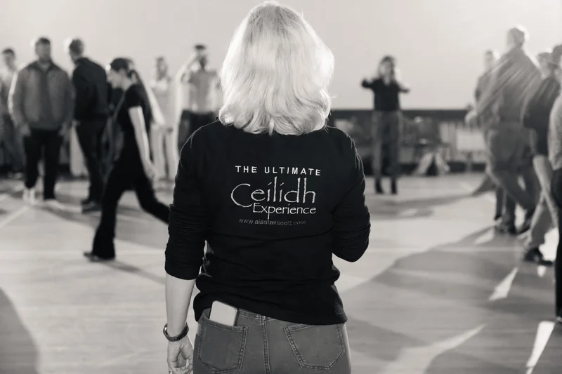 a woman in black and white standing in front of a group of people