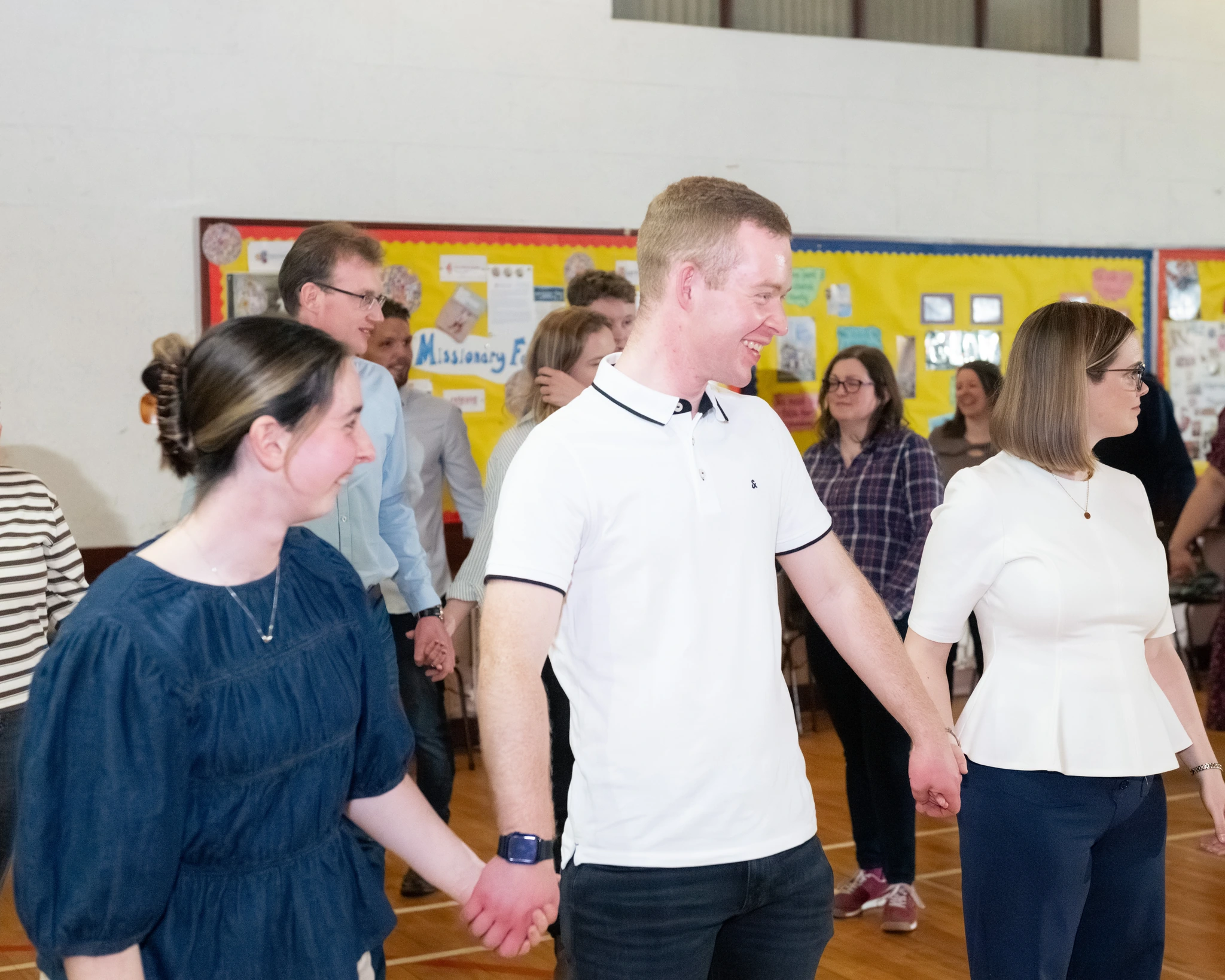 a group of people holding hands in a classroom