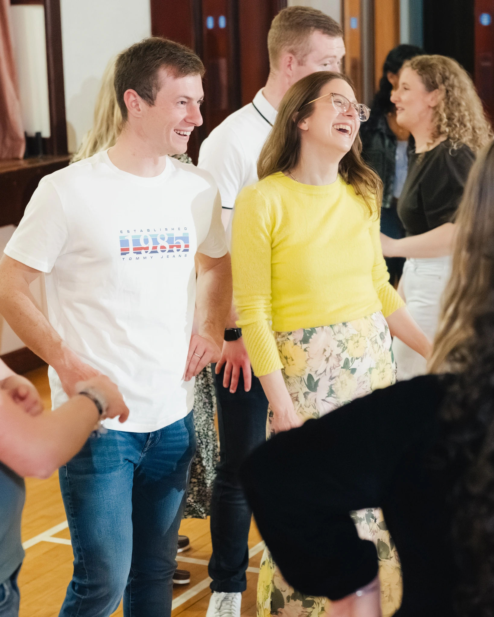 a group of people laughing and dancing in a gymnasium