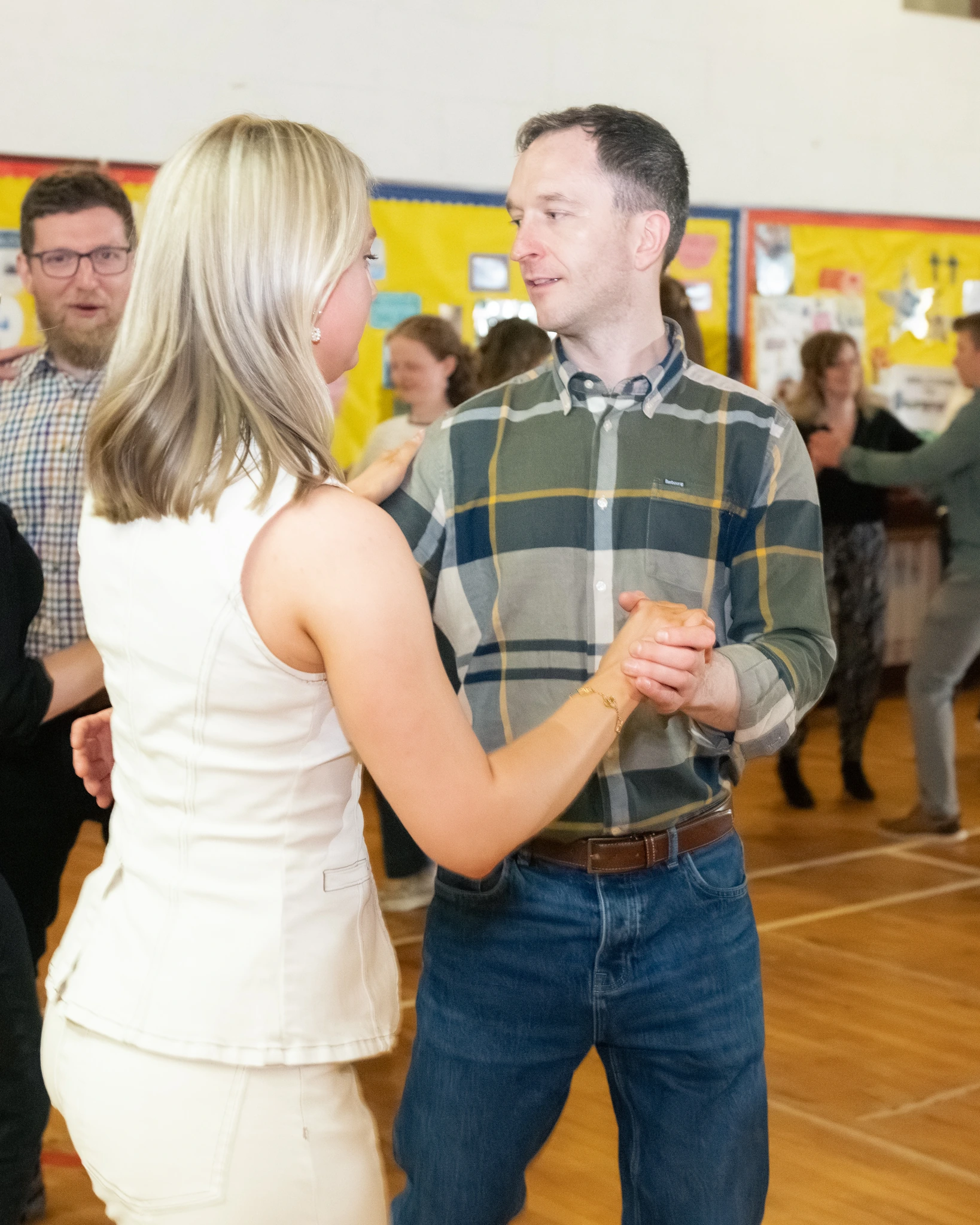 a man and woman dancing in a school hall